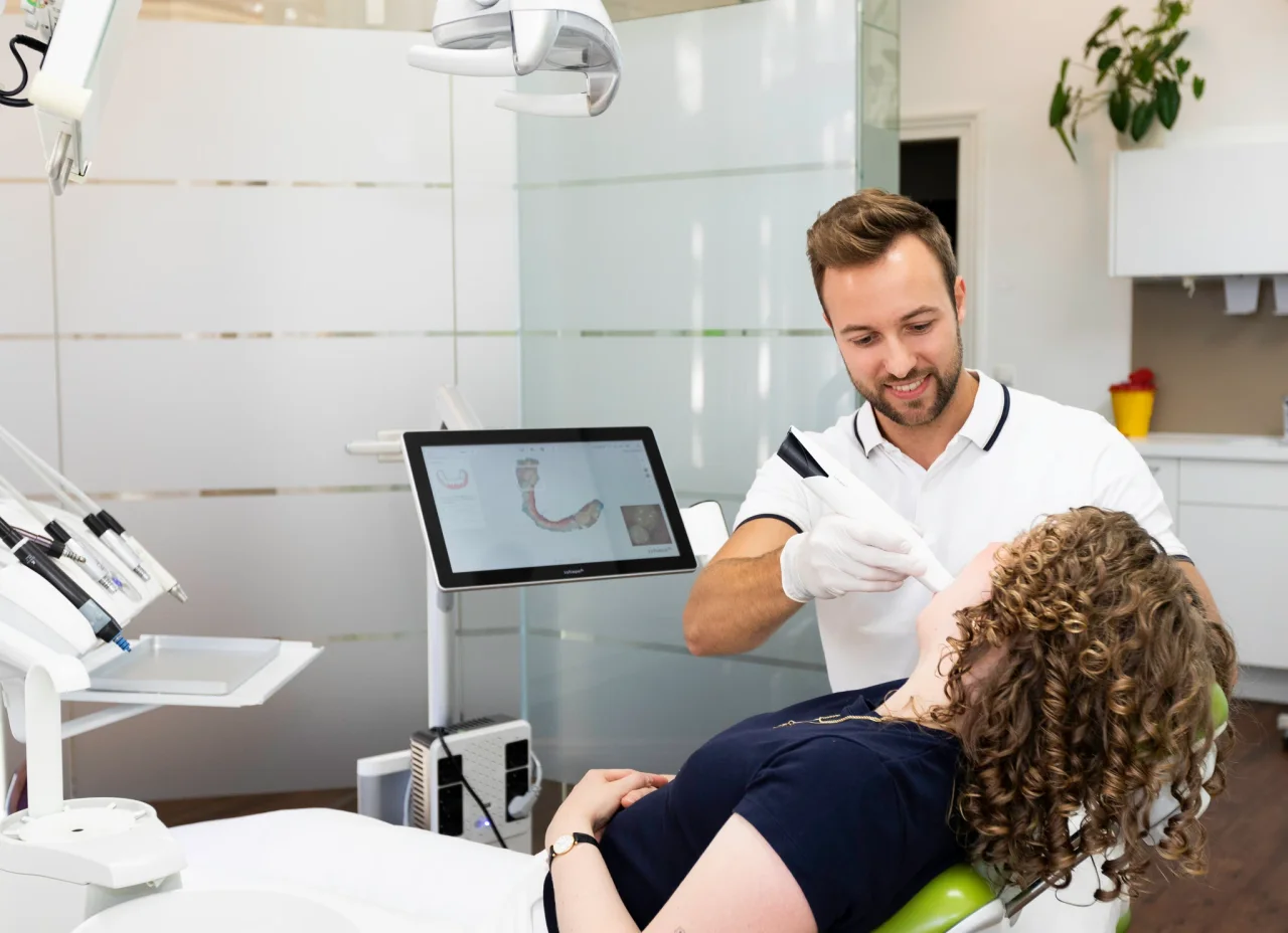 Dr. Alexander Seemann erklärt einer Patientin eine zahnschonende Versorgung mit einem Keramikinlay.